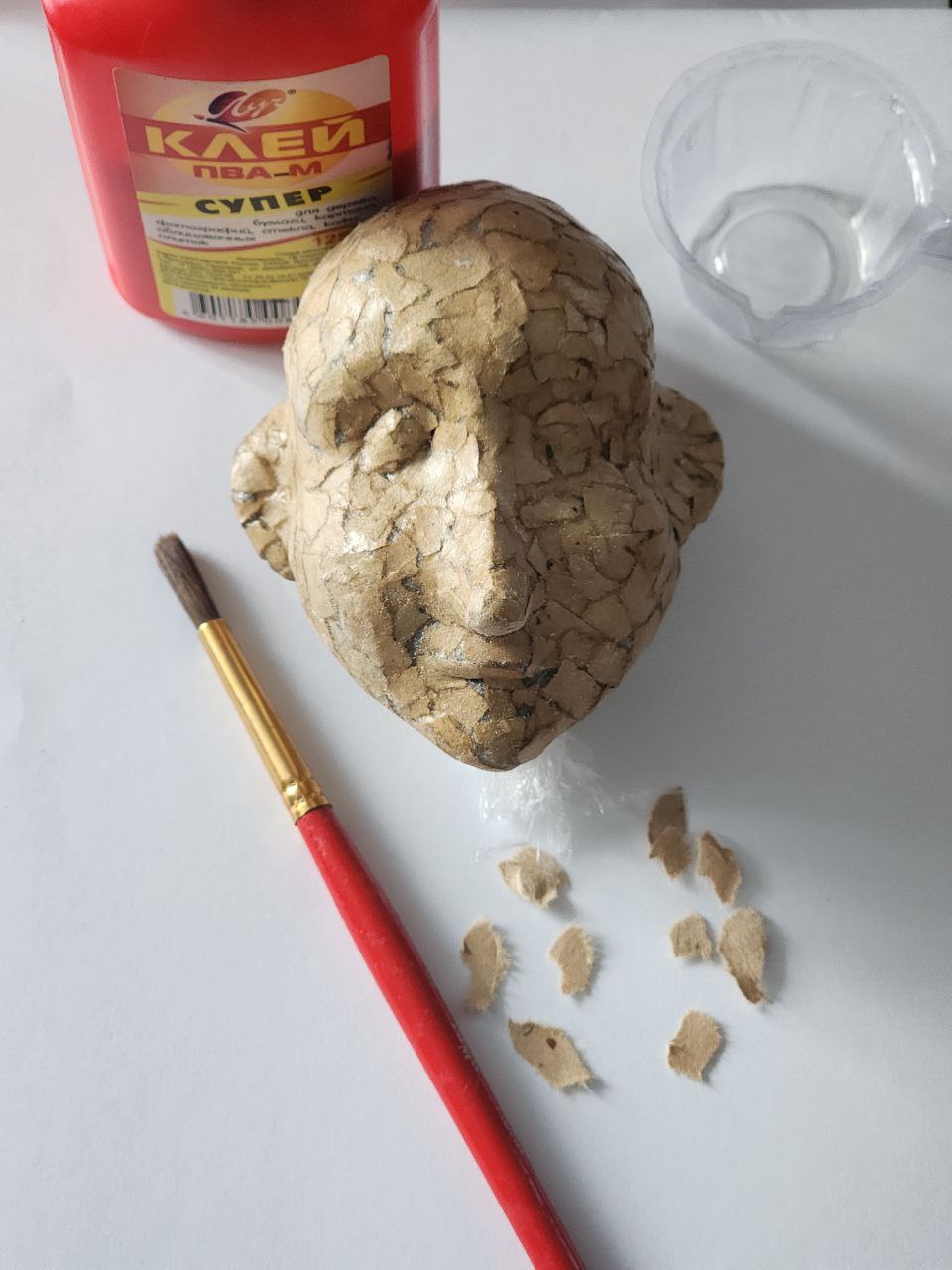 Кукла в процессе создания на рабочем столе с тканями и нитками